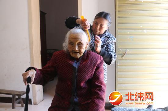 儿媳妇张朝容正在给李明芬老太太梳头